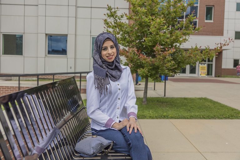 Woman in hijab sitting on bench