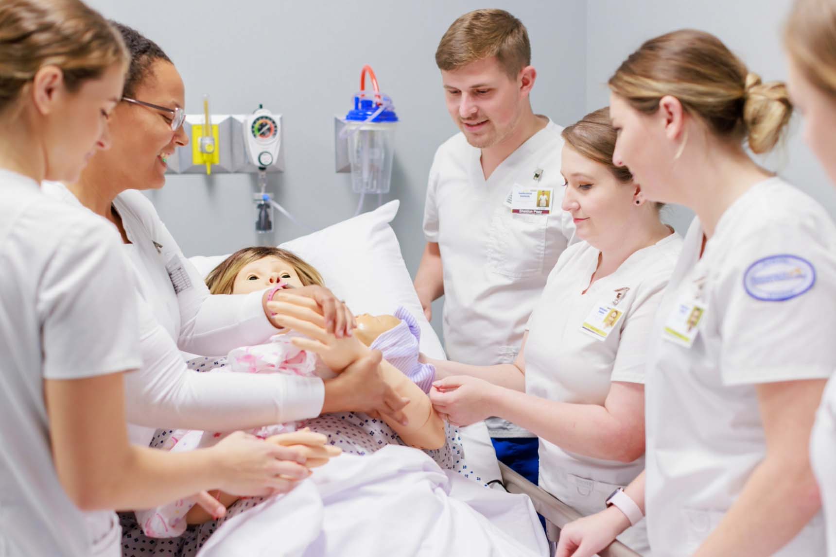 Nursing students working with a manikin.