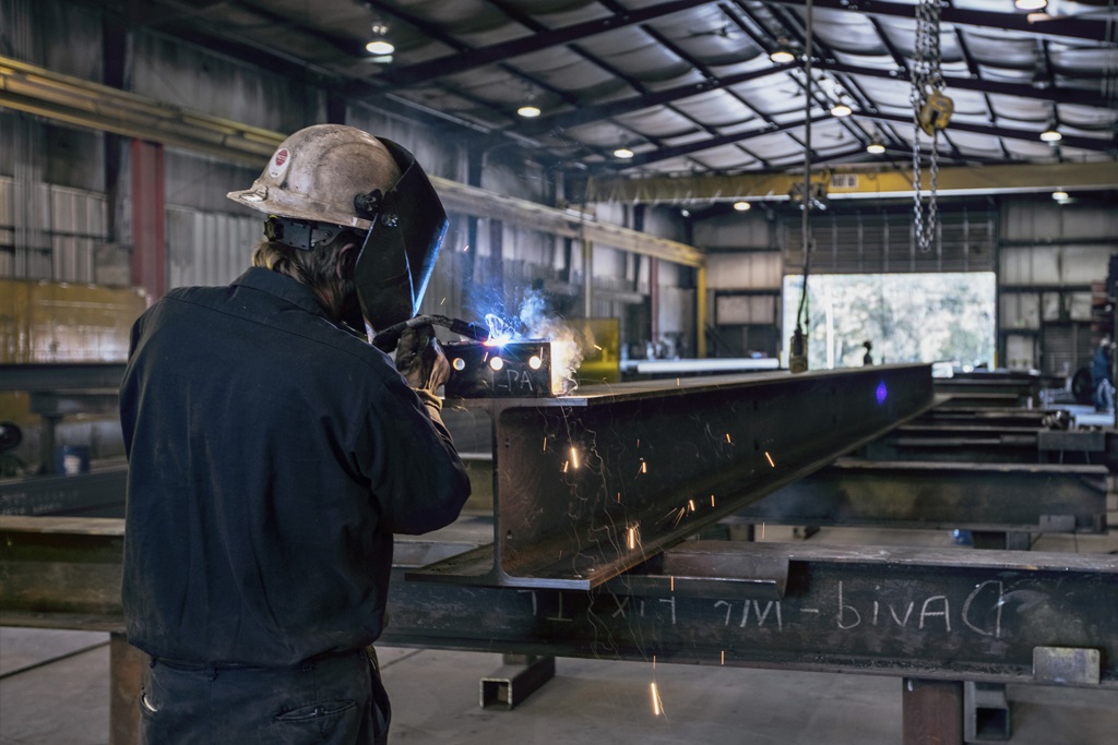 over the shoulder shot of welder working in building