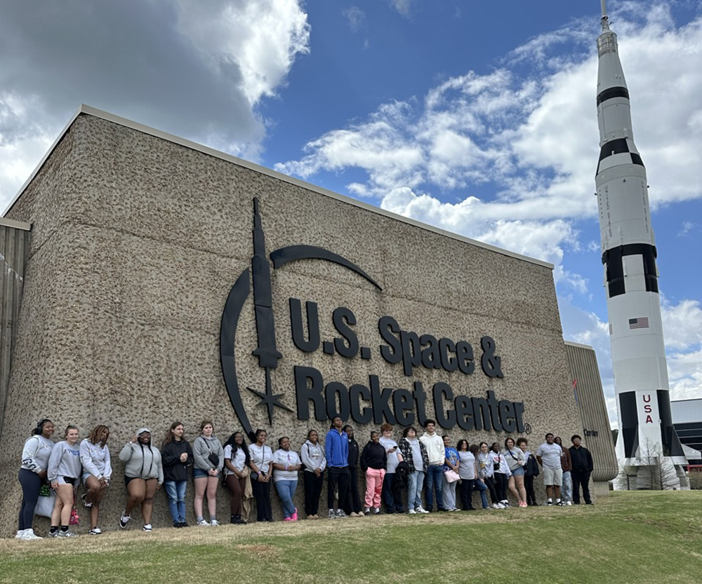 Group of Upward Bound Math & Scirnce students staaning at space center.