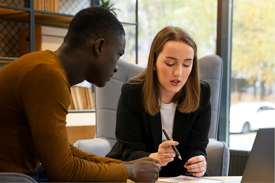 two students sitting inside talking