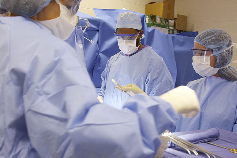 Surgical Technology students in a lab practiceing skills. 