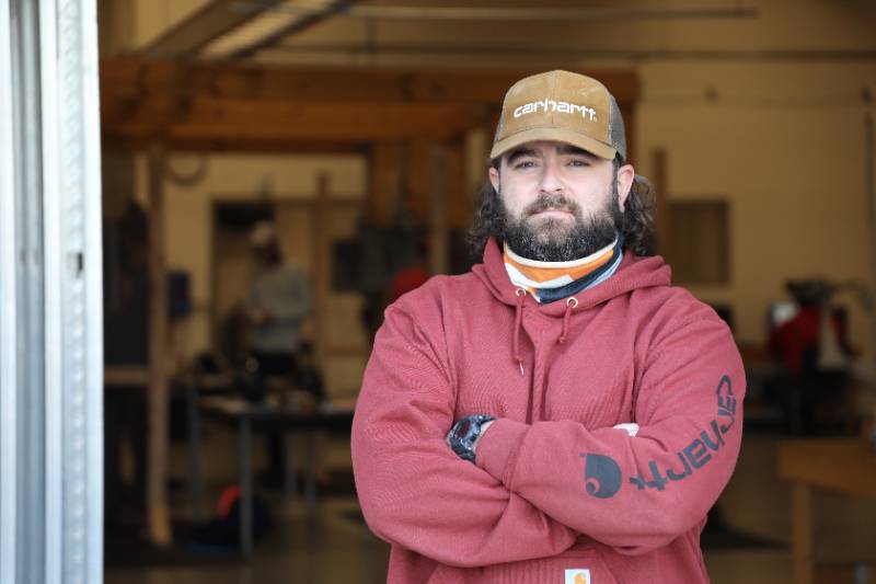 Individual standing with arms folded