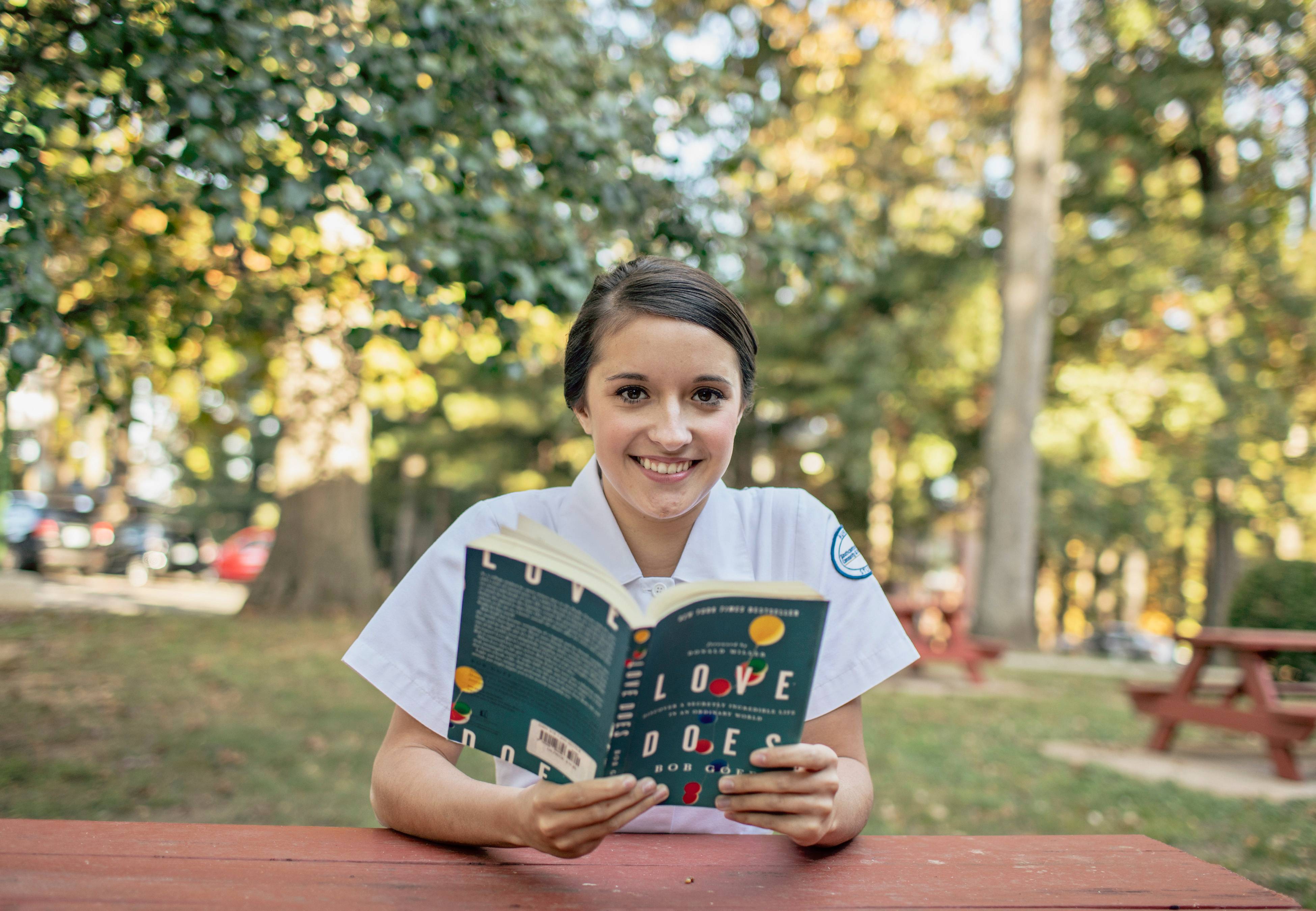 Individual sitting at table with book