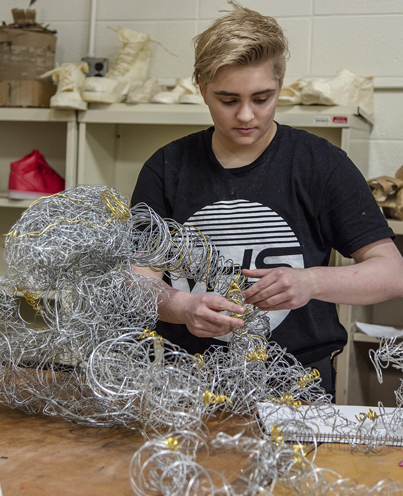 Student working with wire sculpture