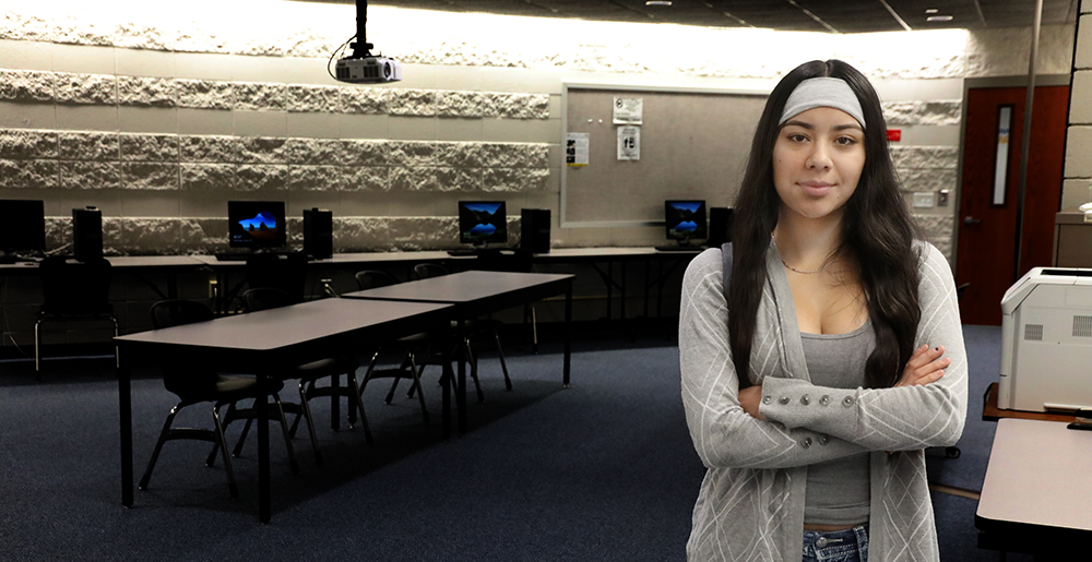 Magdalena Ramirez standing with arms crossed in classroom