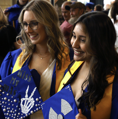 Two femal graduates in cap and gown