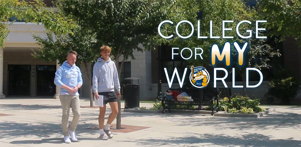 Two male students walking across campus with words college for my world.