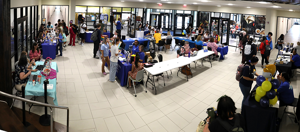 Students standing about clubs and organization tables at Student Life Showcase