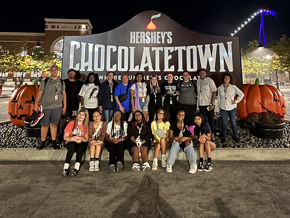 Group of Upward Bound Math and Science students in front of Hershey's sign.