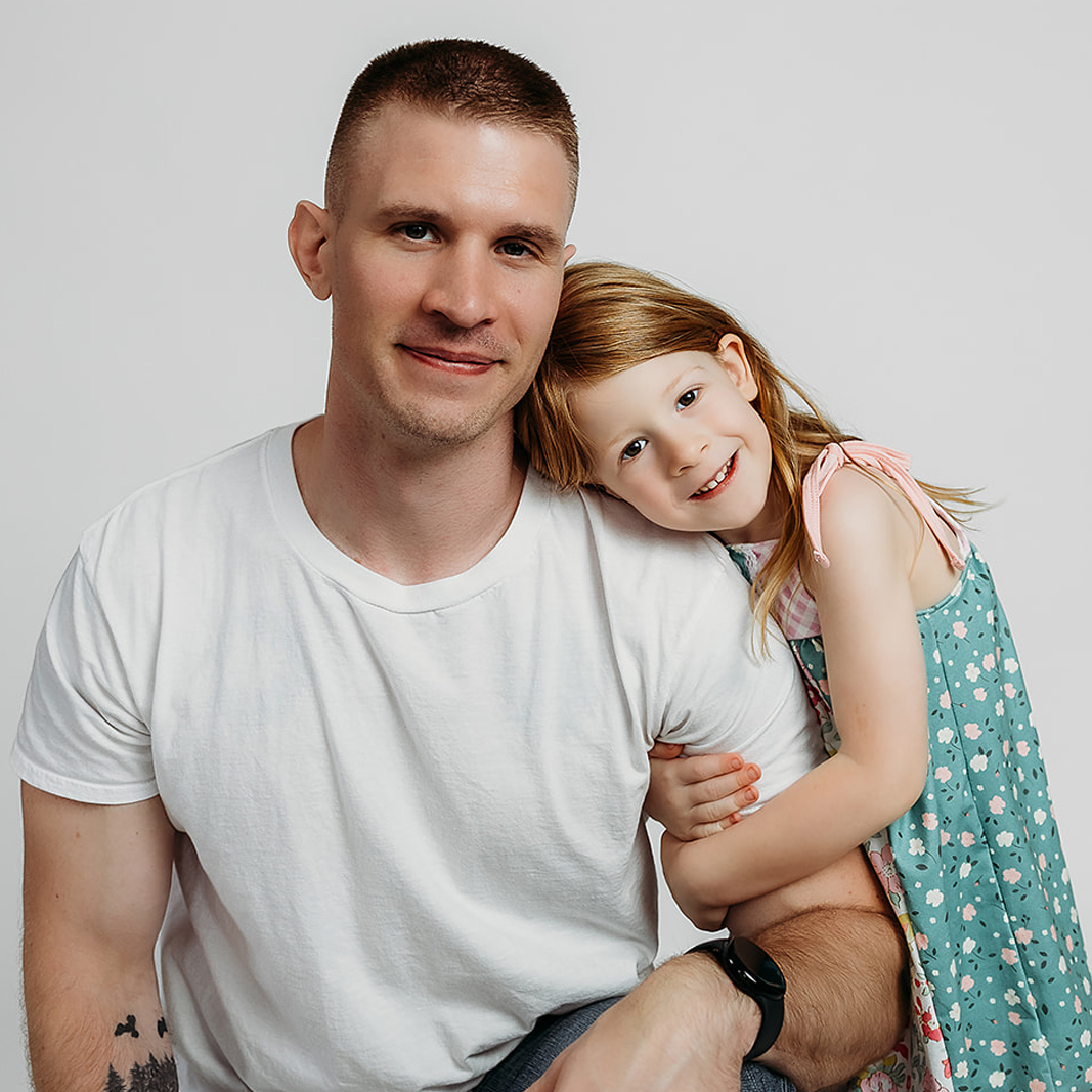 Photo of Nick Conder with daughter hugging his arm