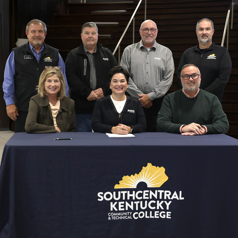 Group of people standing behind a table