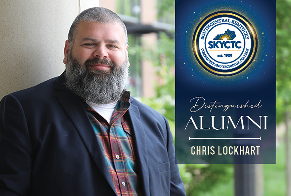 Chris Lockhart leaning on SKYCTC sculpture on college's main campus with distinguished alumni sign
