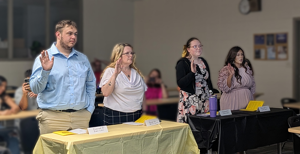 Four student being swarn in to the Gamma Delta Phi honor society