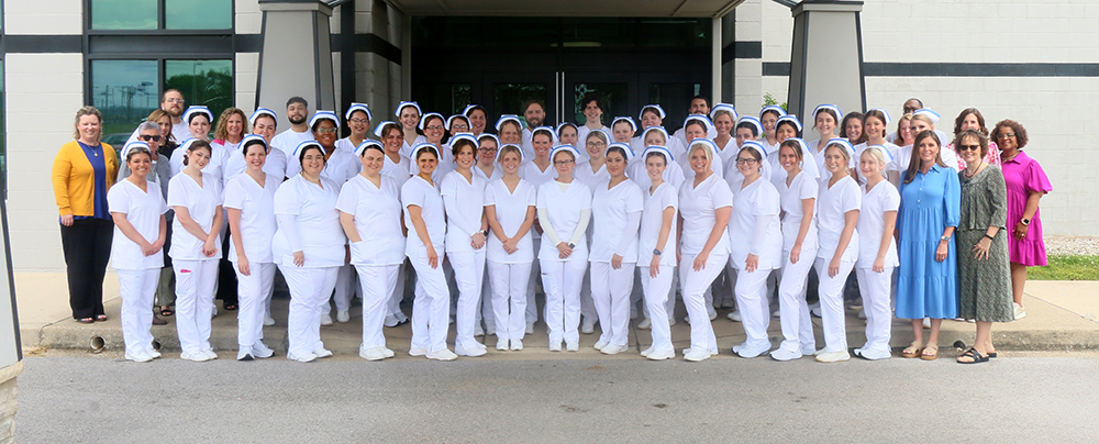 The 46 member group of graduating nurses with their instructors standing in front to Cave Area Convention Center