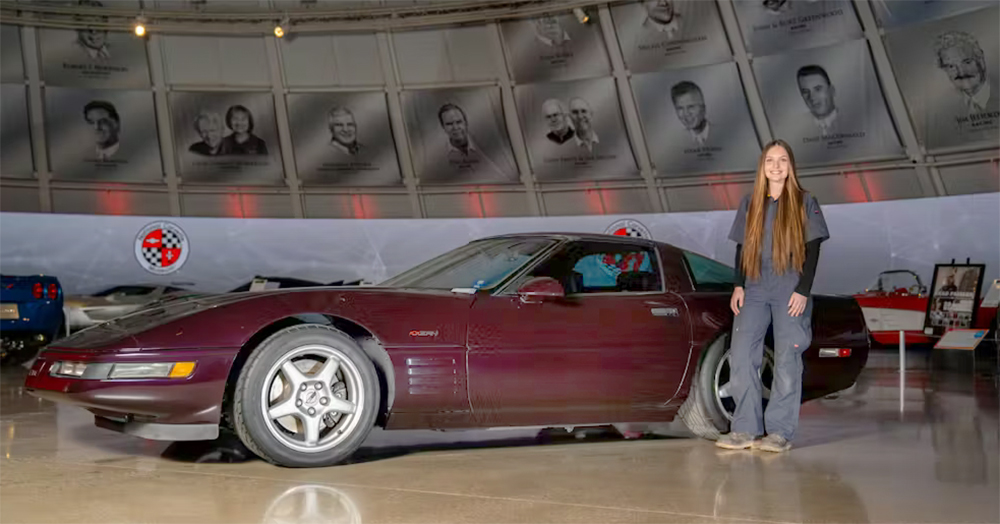 Summer Votaw standing next to restored corvette