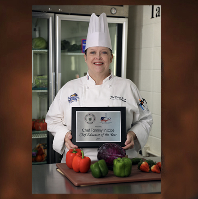 Tammy Inscoe in her Chef uniform holding Educator of the Year Plaque