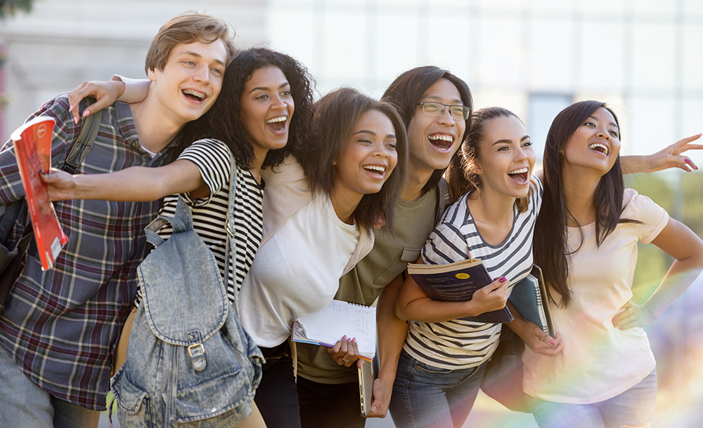 Several college student standing with arms around each other on campus