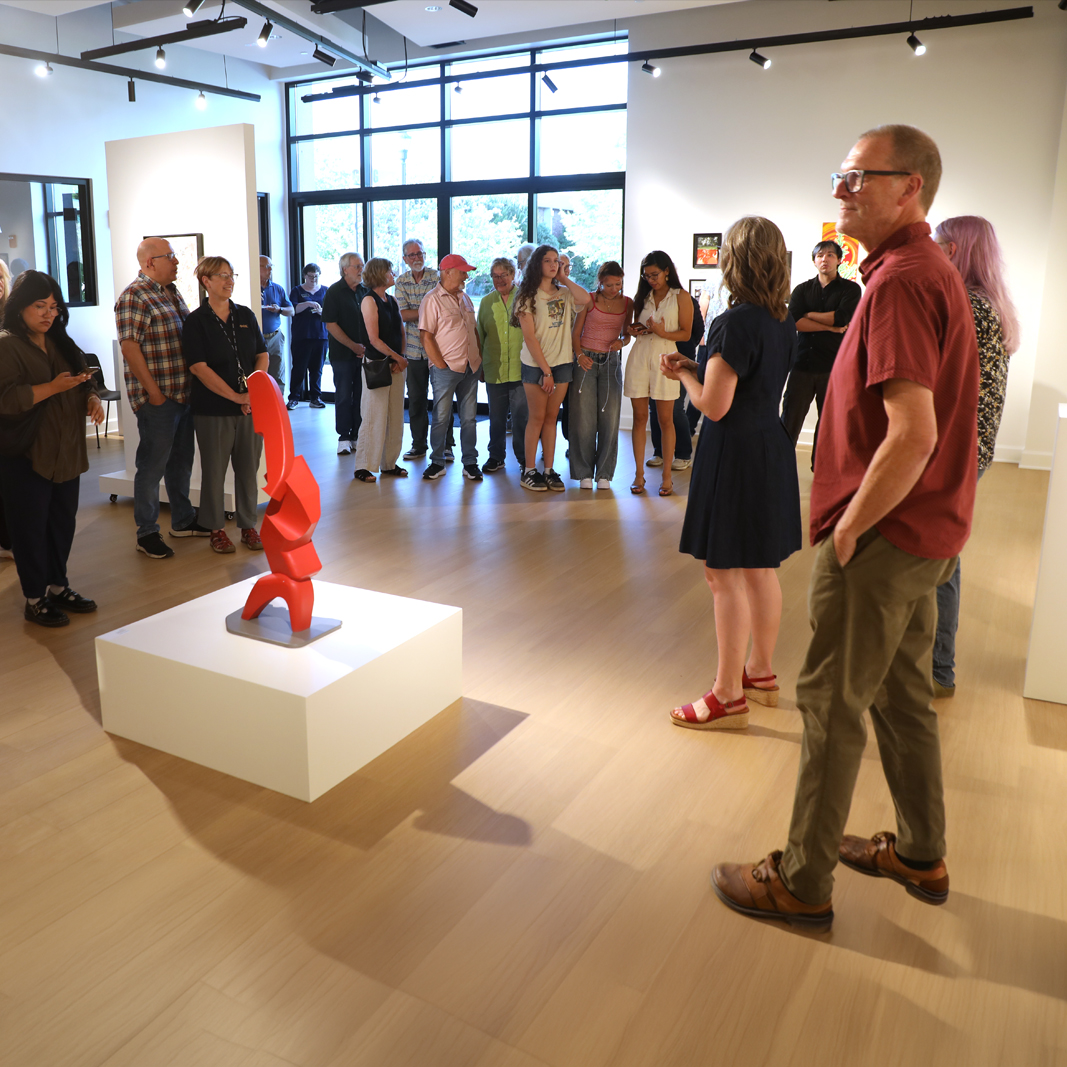 Group of people listing to speaker at art show