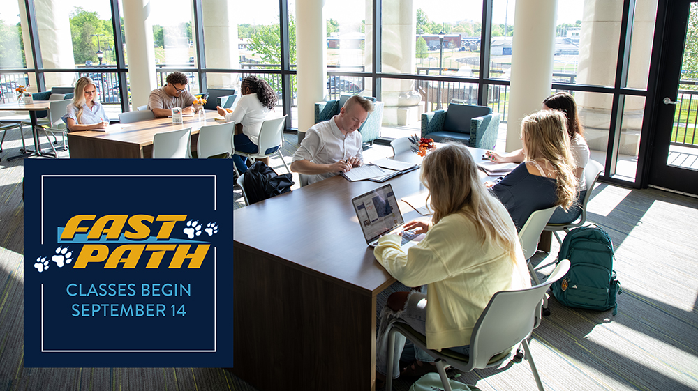 Students studing in library with fast path logo