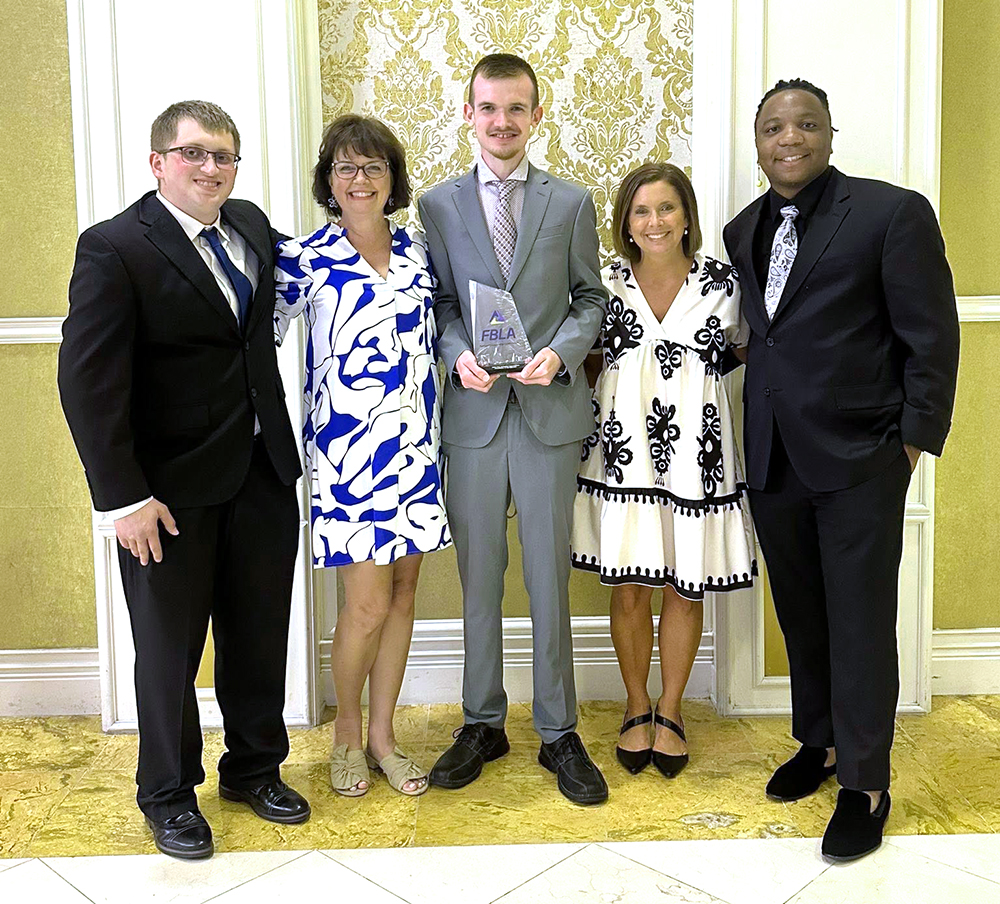 Student and advisors posing with award