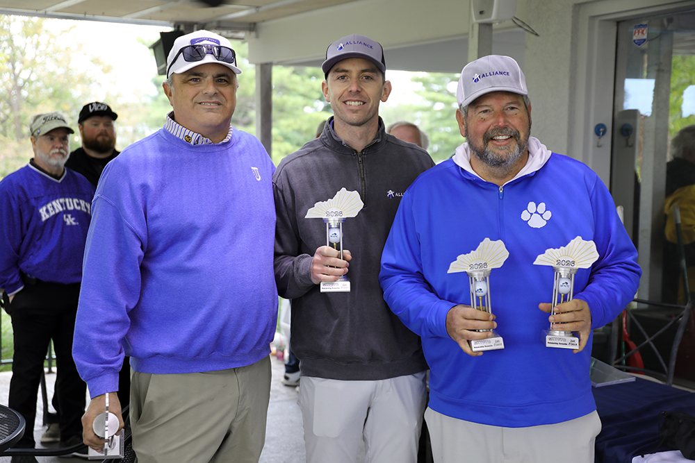 Three men holding first place golf tournament trophys