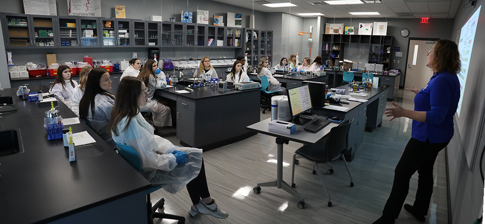 Group of student in a classroom listening to teacher