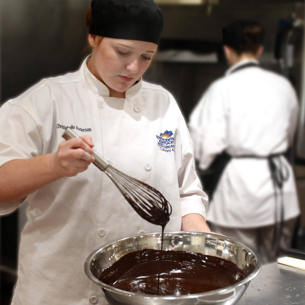 Culinary student stirring a bowl of chocolate 