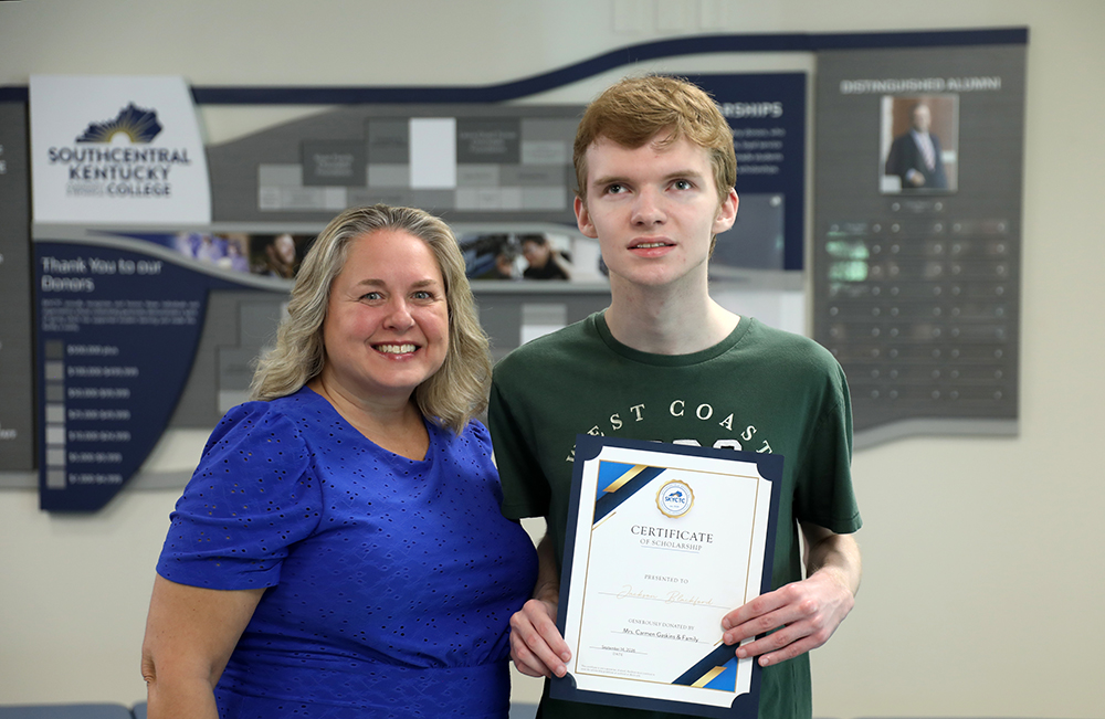 Carmen Gaskins presenting scholarship certificate to Jakson Blackford