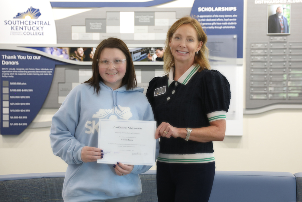 April Harris presents scholarship certificate to Gracie Hayes