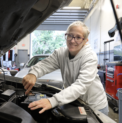 Kesha Collins working on an engine of an automobile