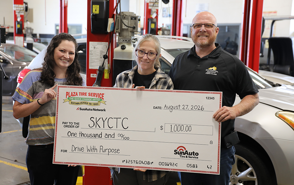 Three people holding an oversized check