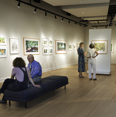People standing in the new art gallery viewing art.