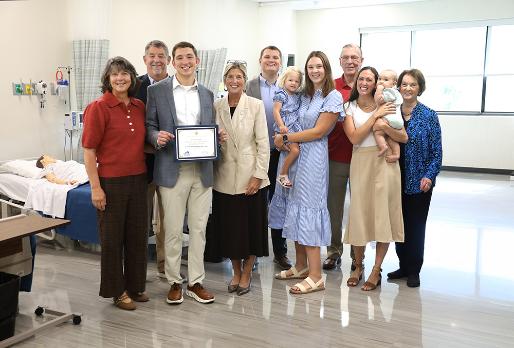 A group oof people presenting a scholarship certificate to the cancellorof hte college