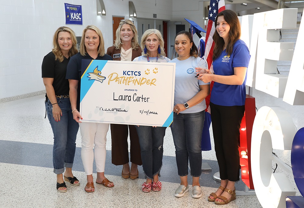 Five ladies standing with Laura Carter presenting her athe Pathfinder Award.