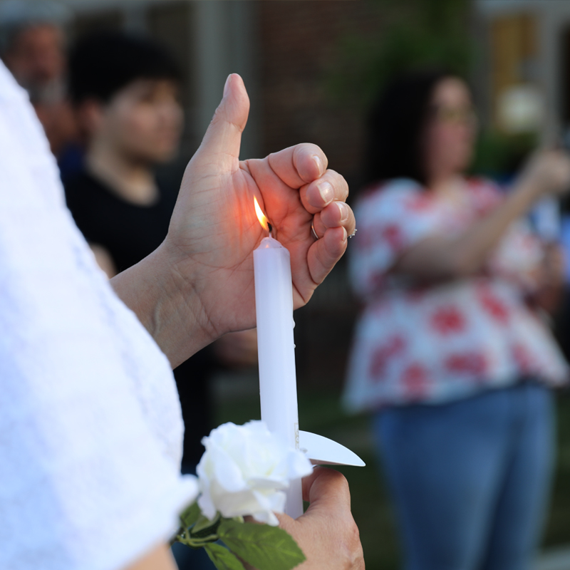 Hand holding a lit candle