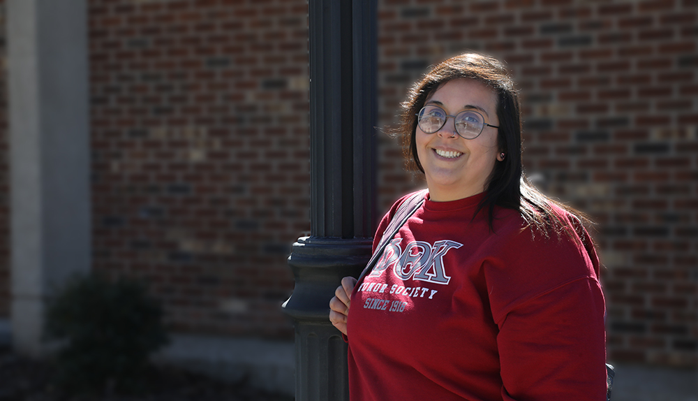 Selena Jones standing next to a light pole on campus