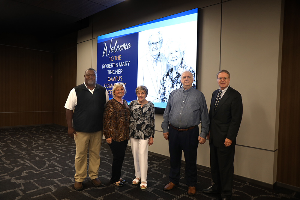 The five members of the Tincher Foundation Board standing in front of image of Robert and Mary Tincher