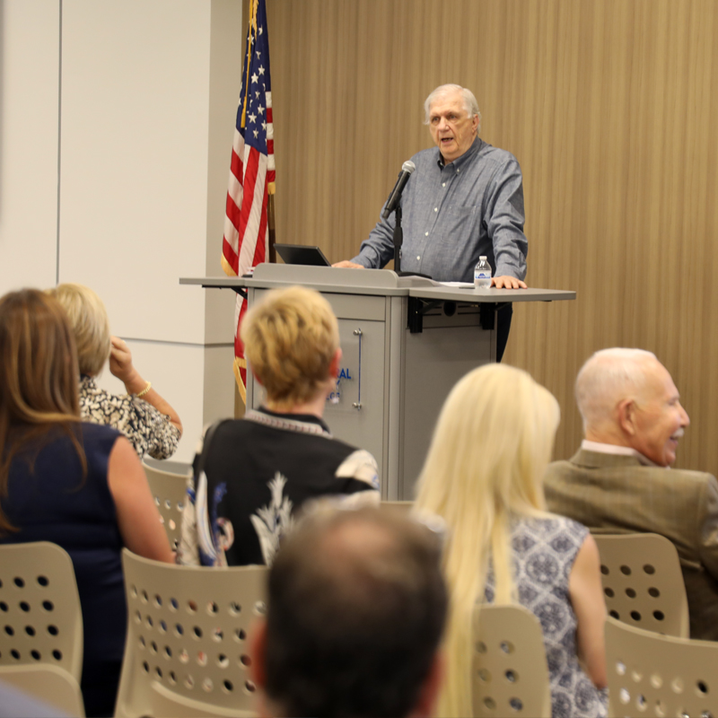 Man speaking to audience at a podium