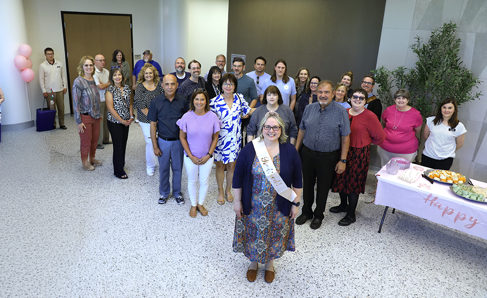 Carmen Gaskins standing in front of a croud of people who came to her retirement reception